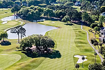 Aerial view of Oak Point Golf Course on Kiawah Island featuring lush green fairways, water hazards, trees, and surrounding residential homes.