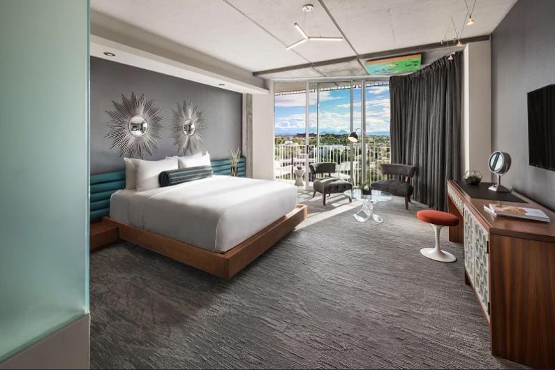 Modern hotel room at Hotel Valley Ho in Scottsdale with a large bed, balcony view, stylish decor, and contemporary furnishings.