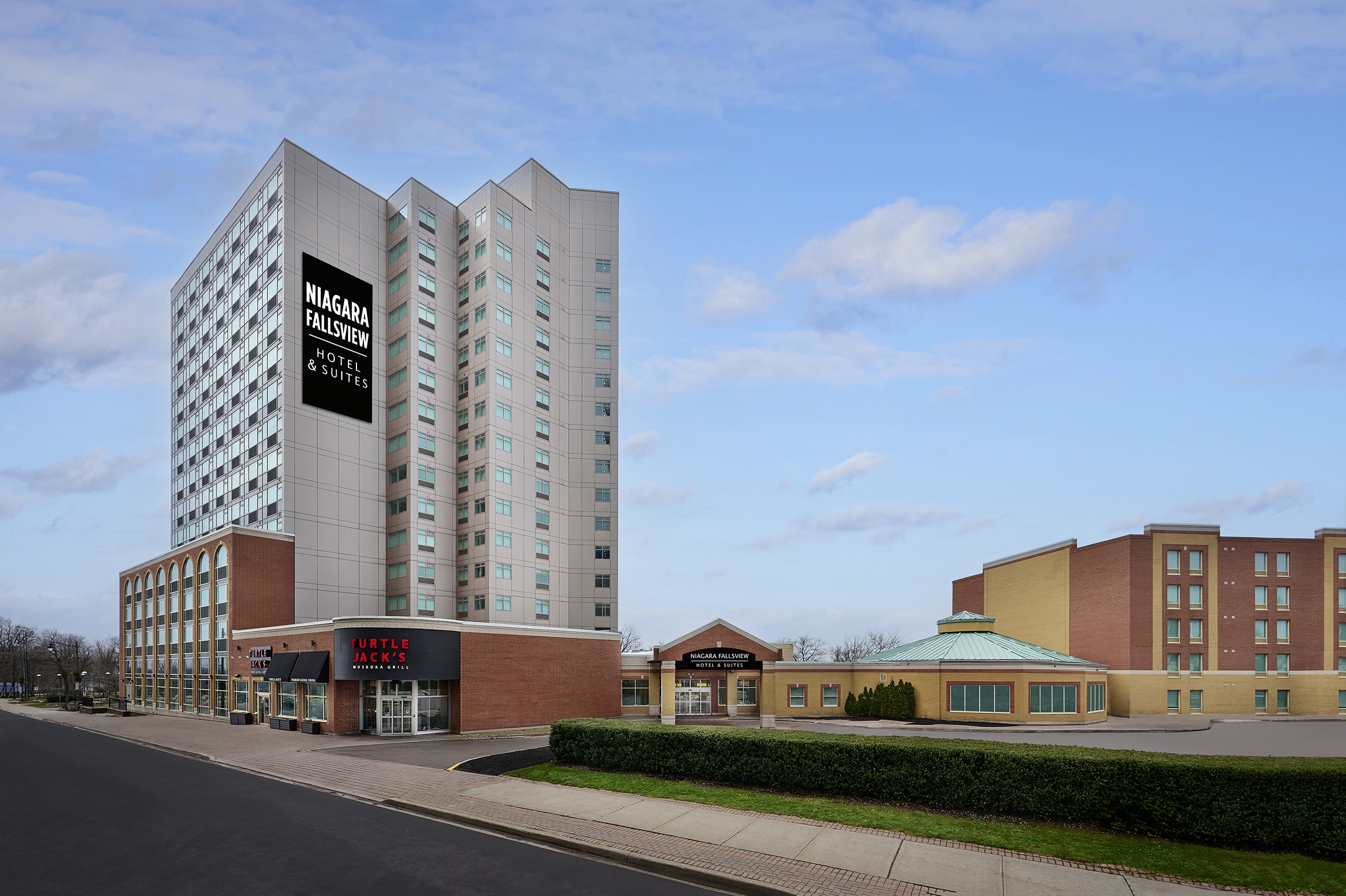 Niagara Fallsview Hotel & Suites Niagara Fallsview Hotel & Suites, a tall modern building with a sign, located near Turtle Jack's restaurant, under a partly cloudy sky.