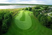 Aerial view of Marlwood Golf & Country Club in Ontario, showcasing a lush green golf course with sand bunkers, surrounded by trees and water.