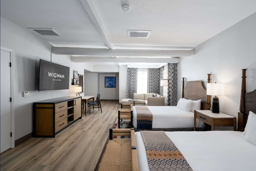 Interior of a modern hotel room at The Wigwam Golf Resort in Phoenix, featuring two beds, a sitting area, and contemporary decor.