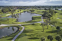 Aerial view of PGA National Resort's Champion Course featuring lush green fairways, water hazards, and scattered trees.