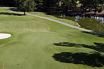 Aerial view of Aberdeen Country Club golf course with lush green fairways, a sand trap, trees, and a water hazard along the Waccamaw River.