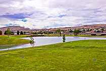 Southgate Golf Club in St. George features a scenic 18-hole course with lush green fairways, a pond, and mountain views.
