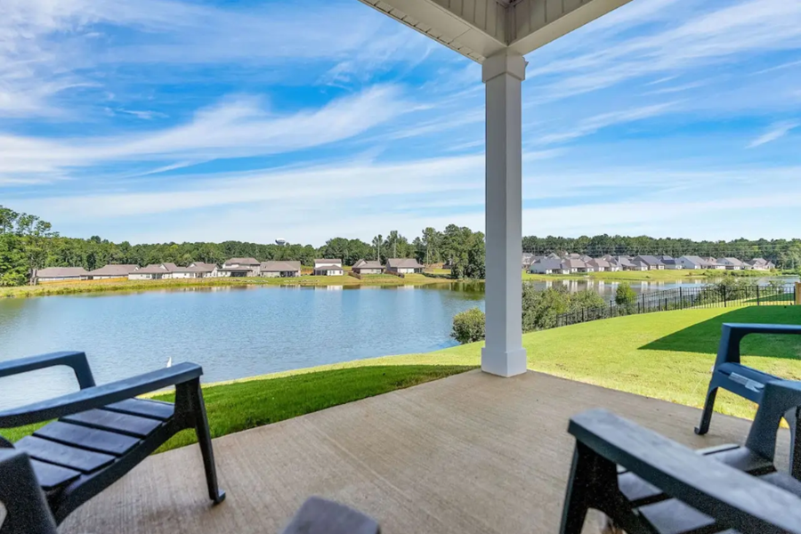 Scenic lake view from the patio of a vacation home in Auburn, featuring lush green lawns and clear blue skies.