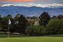Lone Tree Golf Club in Denver with lush green fairways, trees, and snow-capped mountains in the background.