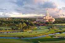 Scenic view of The Biltmore golf course with lush green fairways, water hazards, and the historic hotel building in the background.