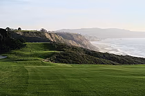 Scenic view of Torrey Pines North golf course with lush green fairways, cliffs, and ocean in the background, perfect for all skill levels.