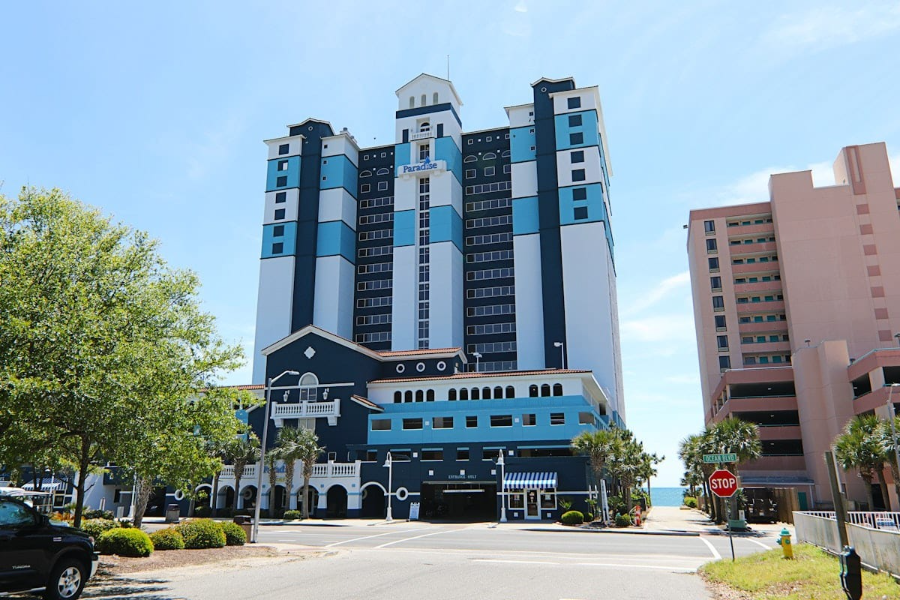 Paradise Resort Oceanfront Paradise Resort in Myrtle Beach, showing a modern high-rise hotel with blue and white accents, ideal for vacations.
