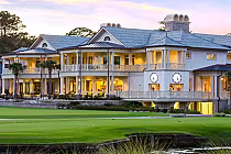 Luxury golf clubhouse with elegant architecture, large windows, and surrounding lush green landscape at Harbour Town Links.