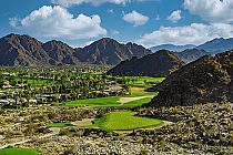 Scenic view of La Quinta PGA West Pete Dye Mountain Course with lush green fairways, desert landscape, and rugged mountains in the background.