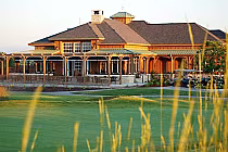 Buffalo Run Golf Course clubhouse with wooden architecture, surrounded by green lawns and golf carts near Denver, Colorado.