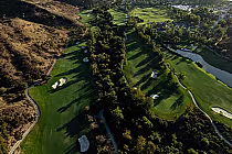 Aerial view of lush green golf course at Arroyo Trabuco Golf Club, featuring rolling hills and sand bunkers, Mission Viejo.