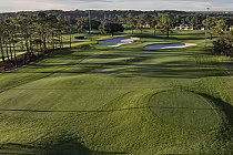 Scenic view of Orange Lake Golf's Legends Walk Course, a lush 9-hole par-3 with sand bunkers and trees, ideal for night golf.