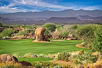 Vibrant green fairway at Troon North Monument Course with desert landscape and rugged mountains in the background.