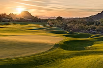 Sunset over the lush green fairways and rolling desert landscape of Boulders Golf Club in Carefree, Arizona.