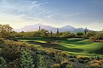Scenic view of a lush golf course at Grayhawk, Arizona, with desert plants and mountains under a clear blue sky.