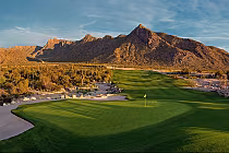 Scenic view of Verrado Golf Club's desert course with lush green fairway and majestic mountains in the background.
