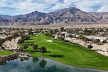 Scenic view of Trilogy Golf Club at La Quinta, featuring green fairways, desert landscape, and mountain backdrop.