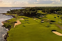 Scenic oceanfront view of Teeth of the Dog golf course with lush greens, sand bunkers, and palm trees at Casa de Campo resort.