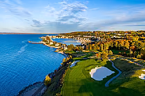 Aerial view of Bay Harbour Golf Club, featuring lush greens and sand traps along the scenic Lake Michigan shoreline.
