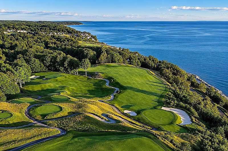 Scenic view of Boyne Golf Course in Michigan with lush greenery, fairways, and overlooking a tranquil blue lake.