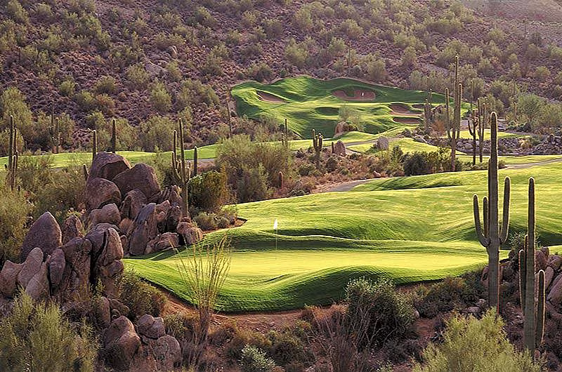 Scenic desert golf course with green fairways, cacti, and rocky landscape in Fountain Hills, Arizona.