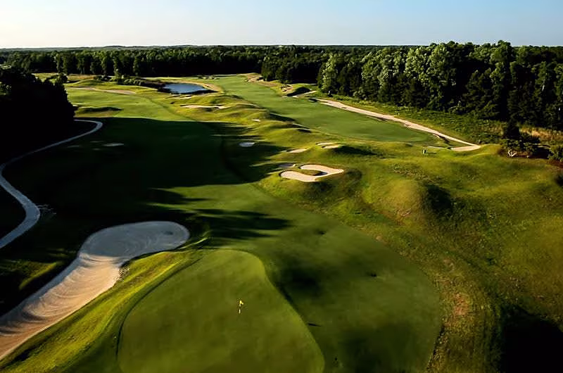 Aerial view of Myrtle Beach Barefoot Resort golf course with lush green fairways, sand bunkers, water hazards, and surrounding trees.