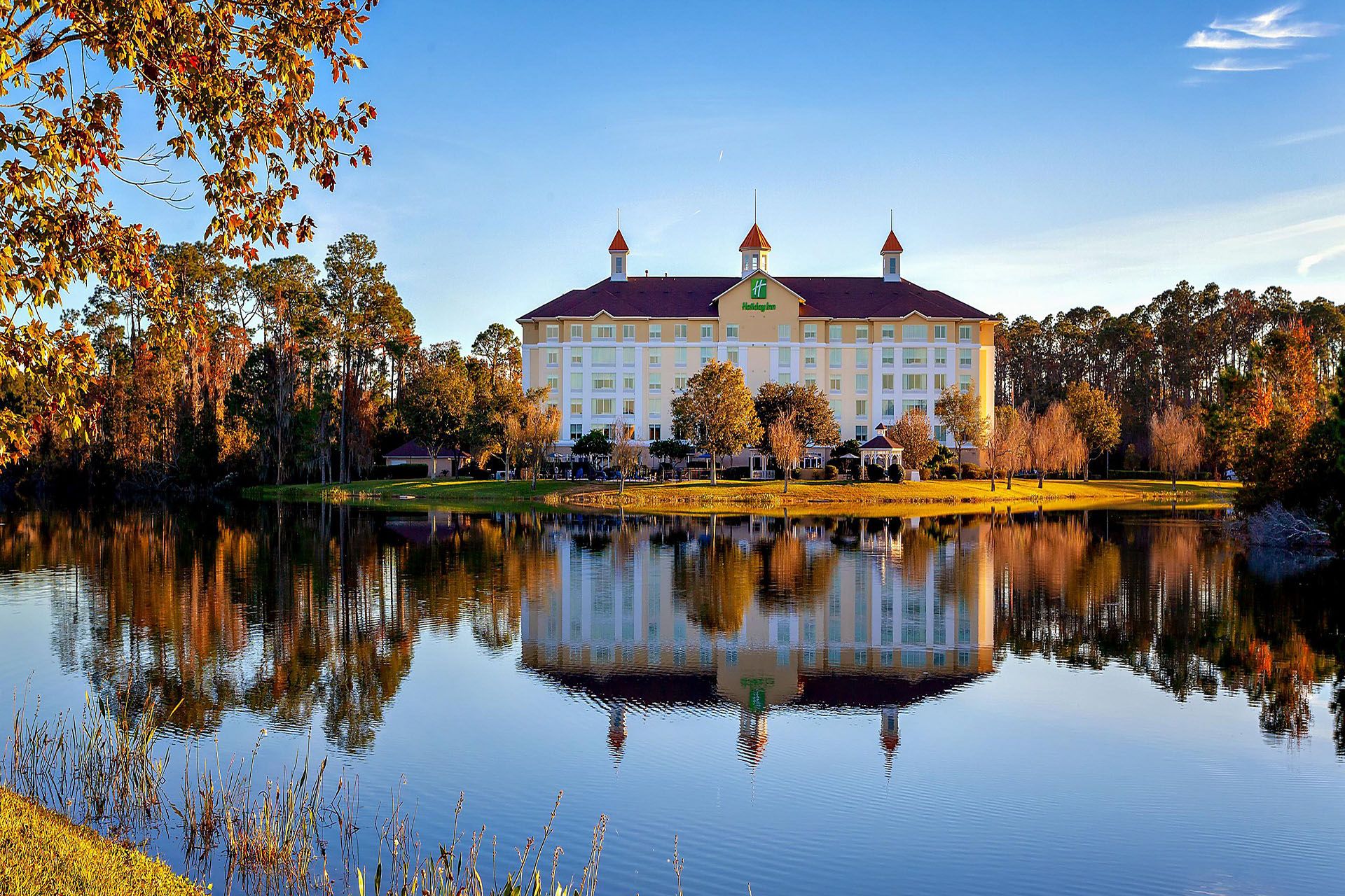 Luxury Holiday Inn hotel with a pond and trees in St. Augustine, offering a scenic golf vacation experience.