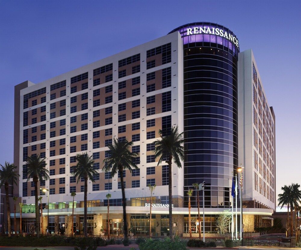 Renaissance Las Vegas Luxury Renaissance Las Vegas hotel with modern architecture, palm trees, and illuminated signage at dusk, perfect for golf vacations.