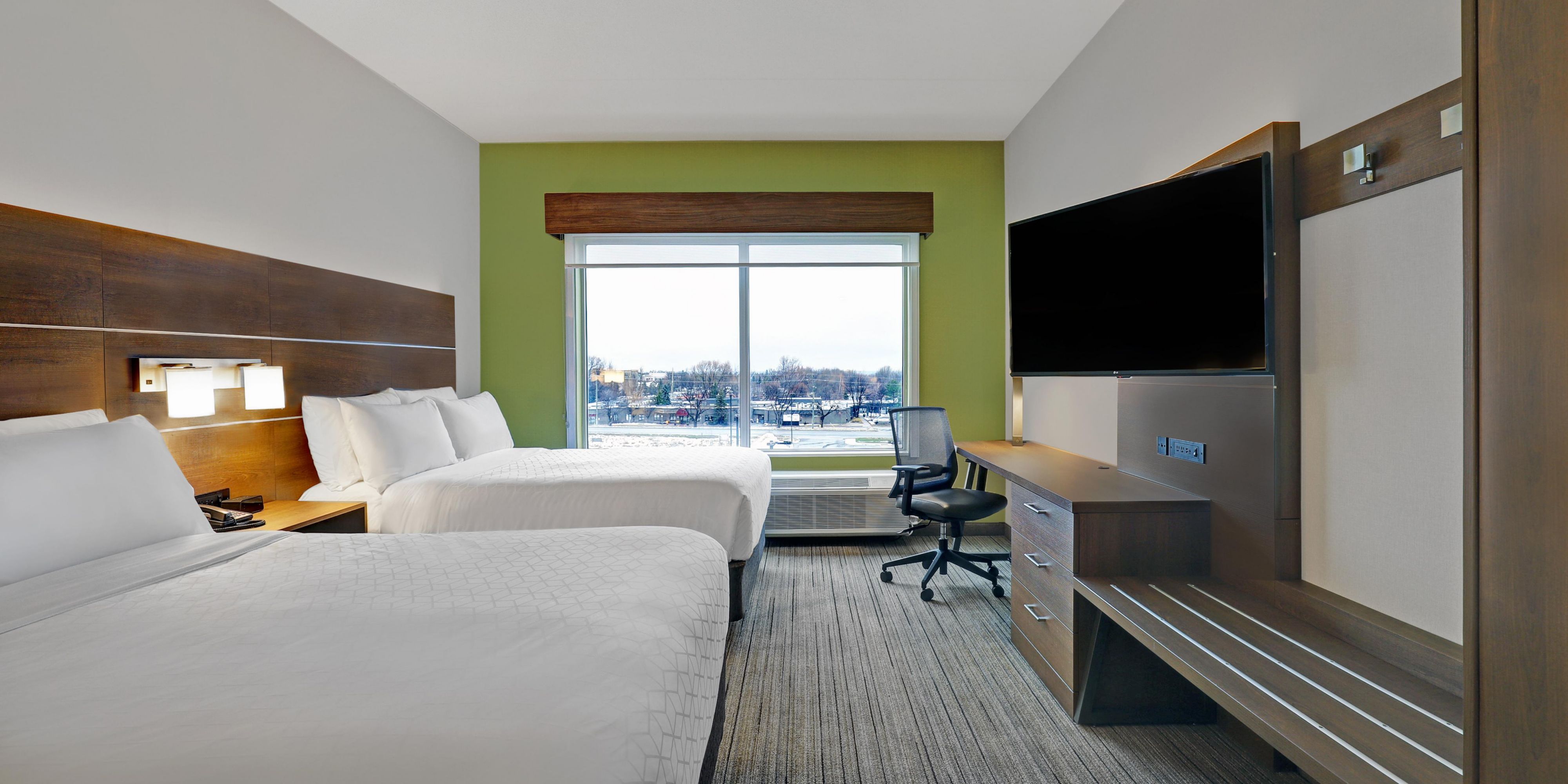 Holiday Inn Express and Suites Collingwood Modern hotel room at Holiday Inn Express and Suites Collingwood with two beds, a large window, and a flat-screen TV.