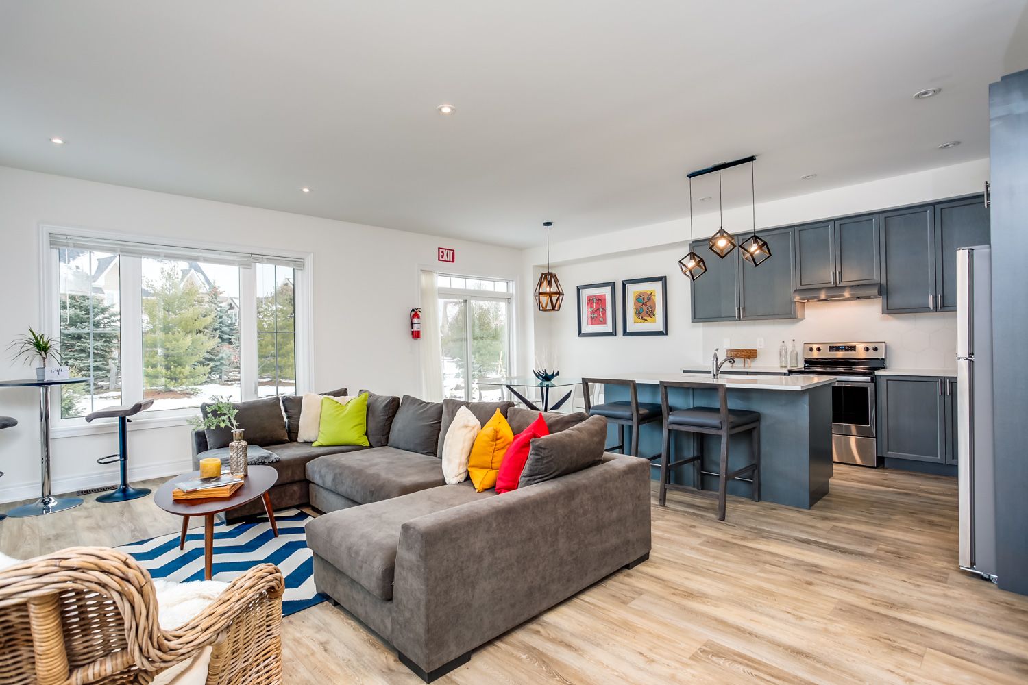 GolfRentalHomes.ca Rental Home Modern rental home interior with a spacious living room, colorful cushions, and a sleek kitchen in Blue Mountain.