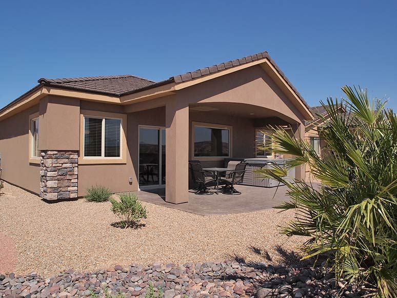 Luxury 2-4 bedroom condo or rental home in Mesquite with a covered patio, outdoor dining area, desert landscaping, and palm trees.