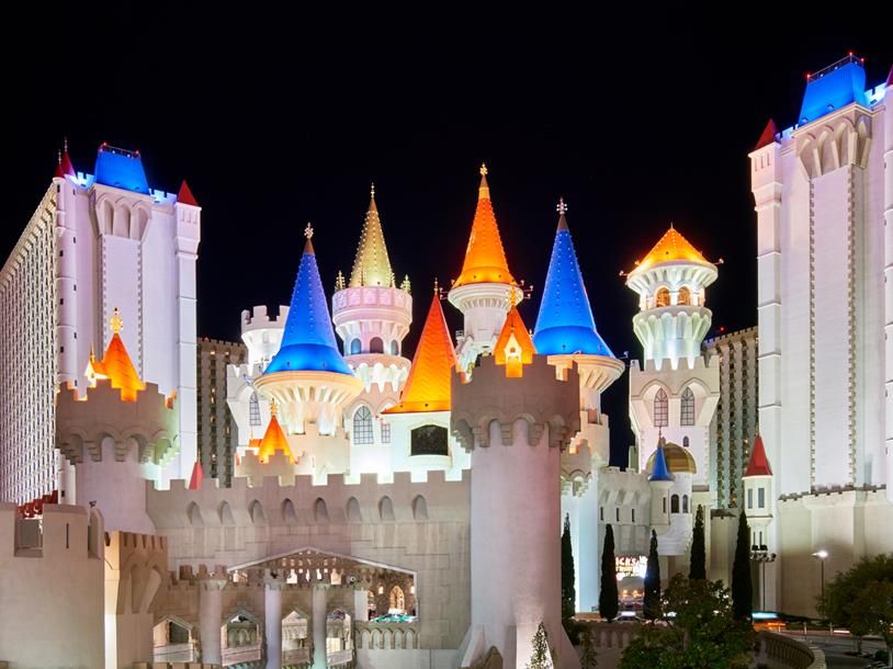 Excalibur Hotel & Casino Colorful castle at Excalibur Hotel & Casino in Las Vegas illuminated at night with bright blue, orange, and yellow turrets.