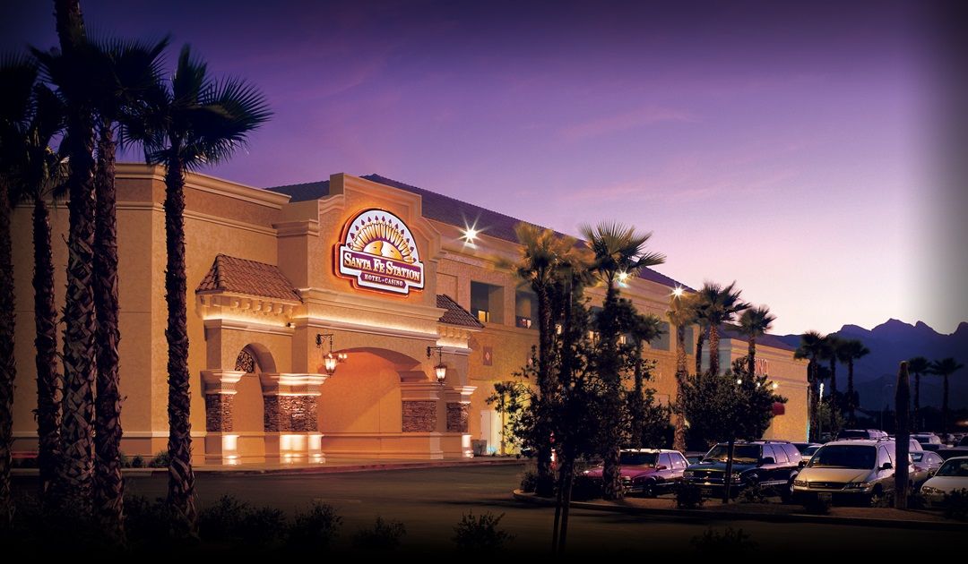 Sante Fe Station Hotel & Casino Santa Fe Station Hotel & Casino in Las Vegas with palm trees and a mountain backdrop at dusk, offering a luxurious golf vacation.