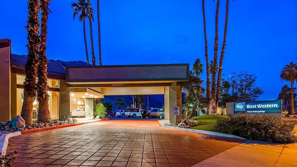 BEST WESTERN INN AT PALM SPRINGS Night view of Best Western Inn at Palm Springs with a lit entrance, palm trees, and a sign, located near Moorten Botanical Garden.