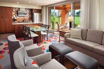 Marriott's Shadow Ridge II- The Enclaves Luxurious living room with modern furniture, colorful carpet, and large windows overlooking a green outdoor area at Marriott's Shadow Ridge II.