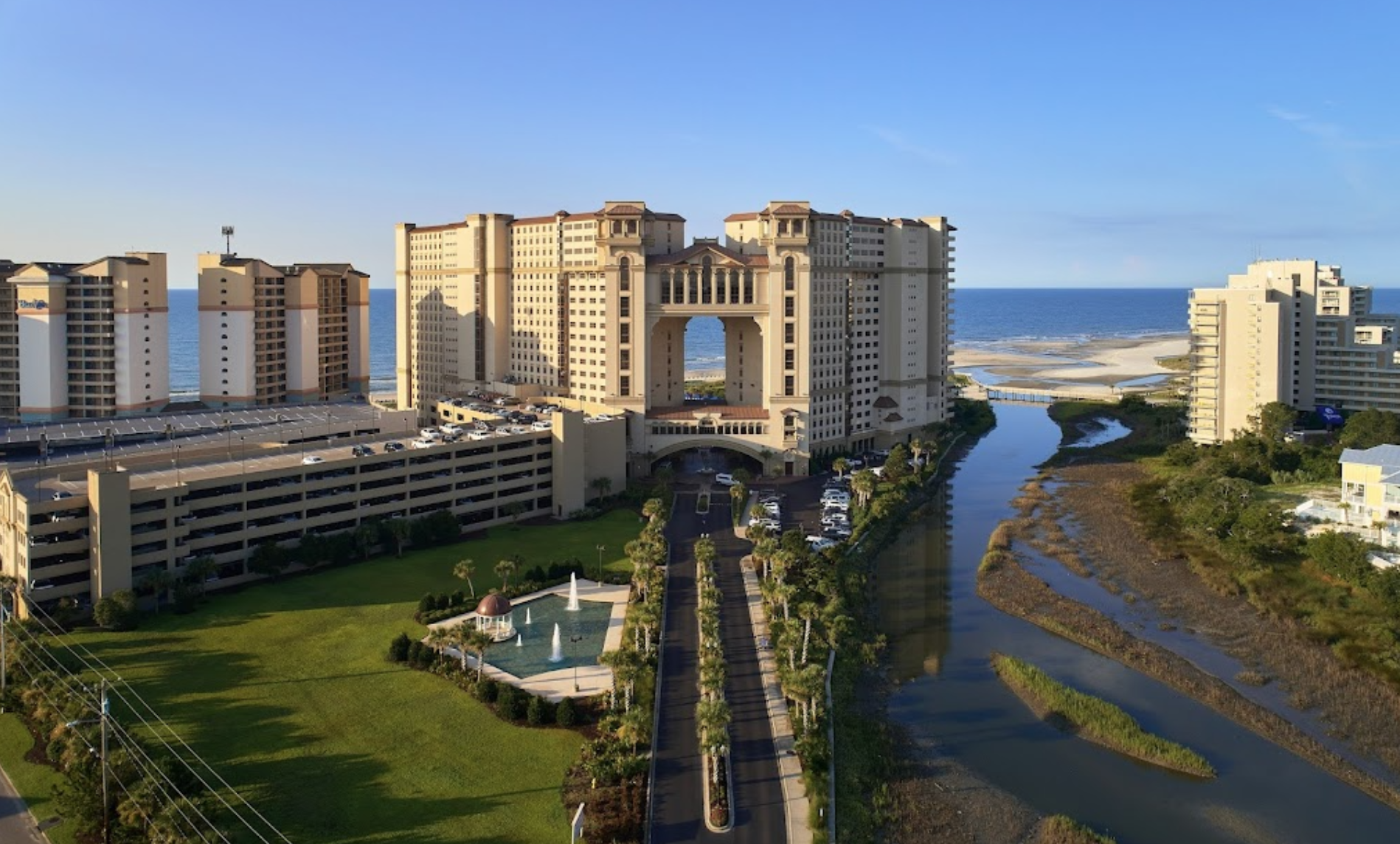 North Beach Resort & Villas Aerial view of North Beach Resort & Villas with tall oceanfront towers, lush green lawns, water features, and the Atlantic Ocean in the background.