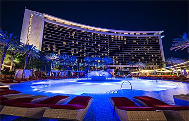 Red Rock Casino Resort & Spa Night view of Red Rock Casino Resort & Spa with illuminated pool, palm trees, and the hotel building in the background.