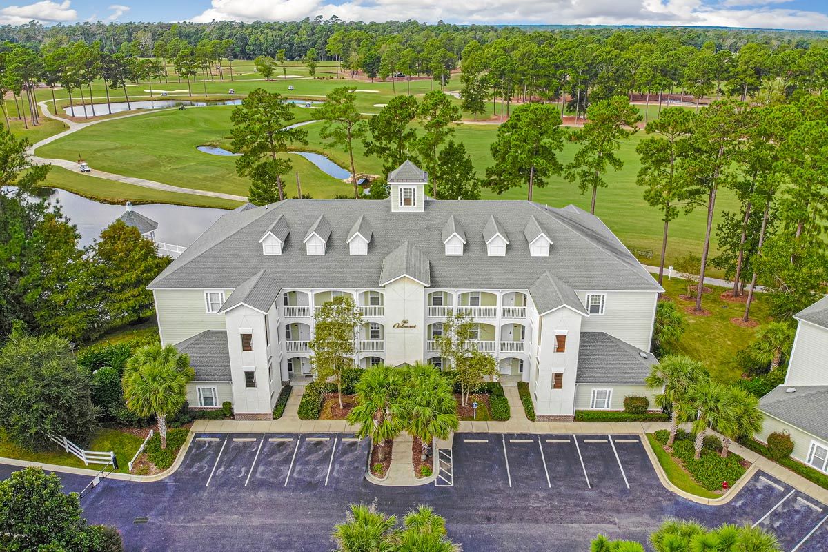 River Oaks Golf Villa Aerial view of River Oaks Golf Villa, a luxury residential complex near golf courses, surrounded by lush greenery and trees.