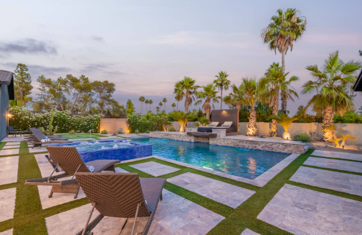 Luxury Scottsdale vacation home with a private heated pool, spa, game room, putting green, palm trees, and outdoor lounge area.