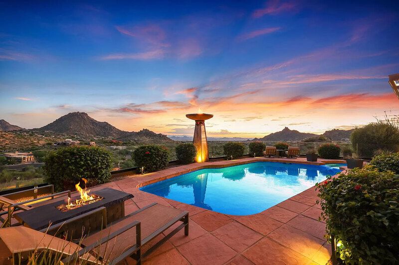 Luxury Scottsdale golf retreat with a pool, fire pit, and scenic mountain views at sunset.