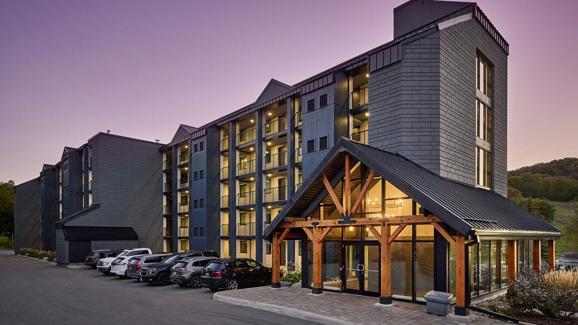 Horseshoe Resort Modern multi-story hotel at Horseshoe Resort, Ontario, with outdoor parking and a welcoming entrance at dusk.
