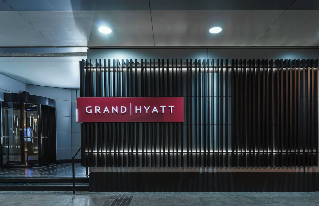 Exterior view of the Grand Hyatt Denver hotel entrance with a modern design and illuminated sign at night.