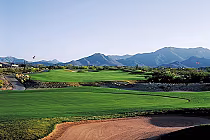 Scenic view of the redesigned McDowell Mountain Golf Course with lush green fairways, mountains in the background, and clear blue sky.