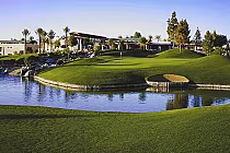 Lush green golf course with a water hazard, sand trap, and a flag, set in a desert oasis at Ocotillo Golf Resort.
