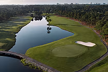 Aerial view of Myrtlewood Palmetto golf course with a water hazard, green fairways, sand trap, and trees along the Intracoastal Waterway.