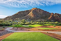 Scenic golf course at Mountain Shadows with green fairways, desert landscaping, and a mountain backdrop under a blue sky.