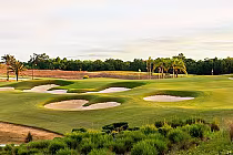 Reunion Resort's Nicklaus golf course designed by Dave Harman, featuring sand bunkers, lush greens, and palm trees.