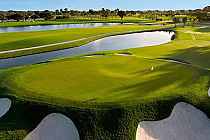 Aerial view of Trump National Doral golf course with lush green fairways, water hazards, sand bunkers, and Miami flora.